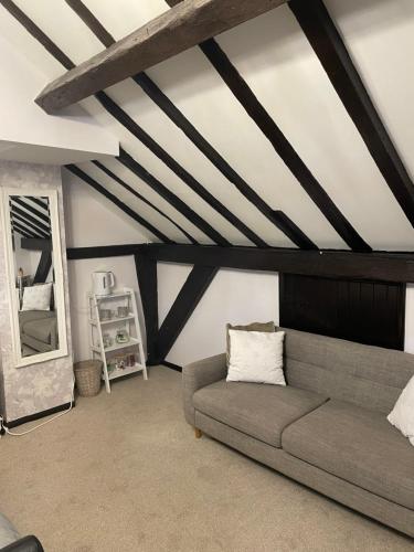 a living room with a couch and a mirror at Coach house hotel in Royston