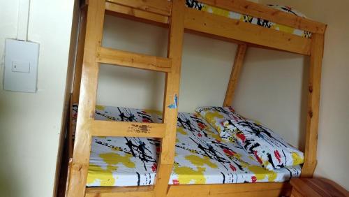 a wooden bunk bed in a room at JO-ZA-NA's Hostel(bed and breakfast) in Baguio
