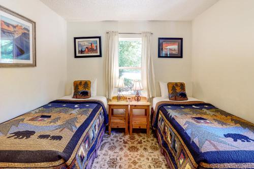 1 Schlafzimmer mit 2 Betten und einem Schreibtisch mit Fenster in der Unterkunft Cottonwood Cottage in Moab