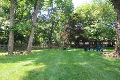 a park with two benches and trees in the grass at The Earl of Sandwich Motel in East Sandwich