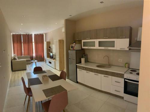 GrudeにあるApartman Vukojaのテーブルと椅子のあるキッチンとリビングルーム