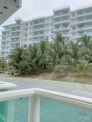 a view of a resort with palm trees and a swimming pool at Comfortable Family Apartment at Sealinks Mui Ne in Ấp Ngọc Hải