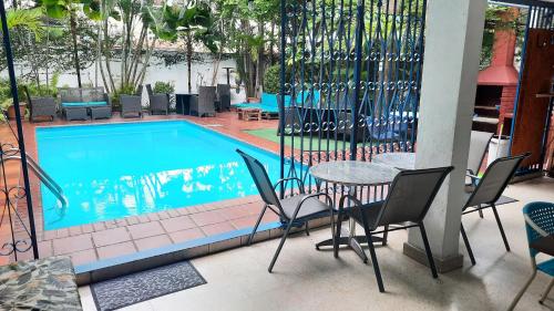 a table and chairs next to a swimming pool at Hostal Yoha in Panama City