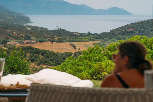 a woman sitting in a chair looking out at the ocean at Villa Dama luxury in Alghero