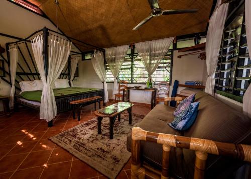 a room with a bed and a couch and a table at Table Rock Lodge in Cristo Rey