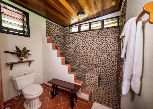 a bathroom with a toilet and a spiral staircase at Table Rock Lodge in Cristo Rey