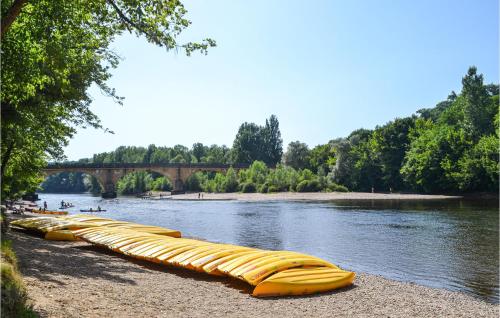 a row of canoes lined up on the shore of a river at 2 Bedroom Lovely Home In Vitrac in Vitrac