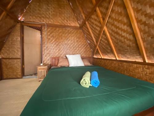 Una habitación con una cama verde en una yurta en D' Tepi Danau Glamping en Kintamani