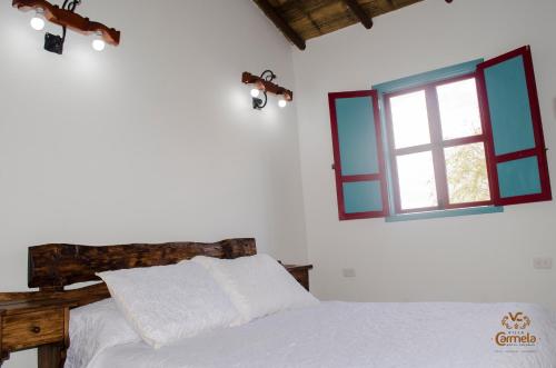 a bedroom with a bed and a window at HOTEL COLONIAL VILLA CARMELA in Tota