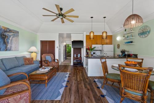 een woonkamer met een bank en een tafel bij Quiet Kiahuna plantation , New Remodel with AC in Koloa