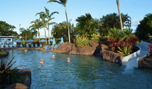 a pool at a resort with people in the water at Quiet Kiahuna plantation , New Remodel with AC in Koloa