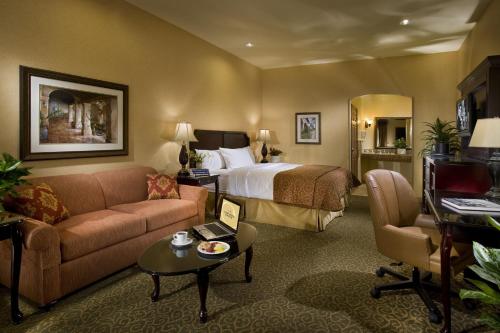 une chambre d'hôtel avec un lit, un canapé et une table dans l'établissement Ayres Hotel Redlands - Loma Linda, à Redlands