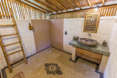 a bathroom with a sink and a ladder and a mirror at Milo's Home in Jimbaran