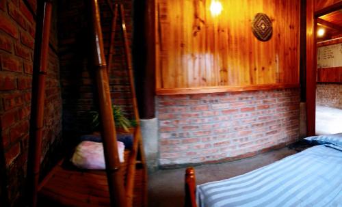 a small room with a bed and a brick wall at Surelee Homestay in Sa Pa