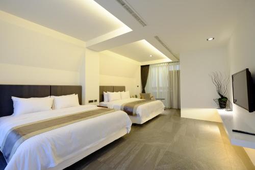 安平的住宿－同棧，酒店客房设有两张床和一台平面电视。