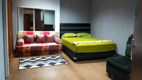 a room with two beds and a couch and a chair at Strategic Jakarta Pavilion in Jakarta