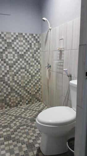 a bathroom with a toilet and a tiled floor at Strategic Jakarta Pavilion in Jakarta