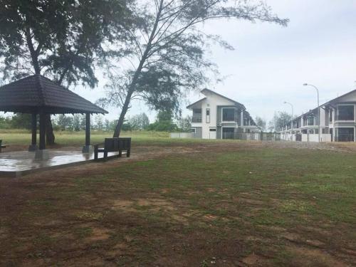 Kampong GambutにあるSemi D Pengerang Johorの雨の中のベンチと傘を備えた公園