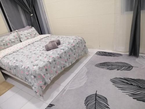 - une chambre avec un lit et une couette dans l'établissement Teratak Sherra Roomstay, à Macang