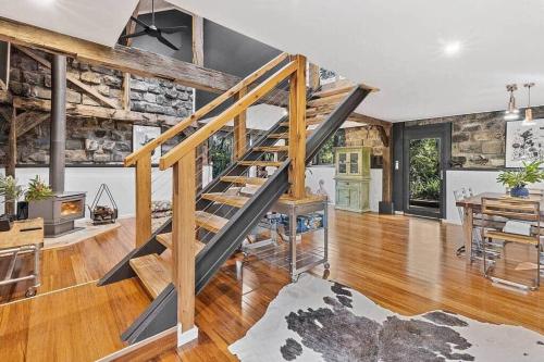 a living room with a staircase and a dining room at Woodlands Retreat in Ocean Grove