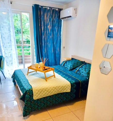 a bedroom with a bed with a table on it at Studio Hibis Blue in Cayenne