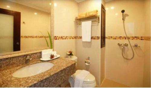 a bathroom with a sink and a toilet and a shower at Ivory Palace Hotel in Pattaya Central
