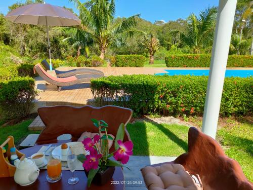 una mesa, sillas y una sombrilla en un patio en Orchidilla Residence Phuket Mai Khao Beach - SHAPlus, en Mai Khao Beach