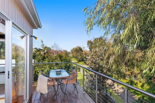 a patio with a table and chairs on a balcony at The Lake House in Ocean Grove