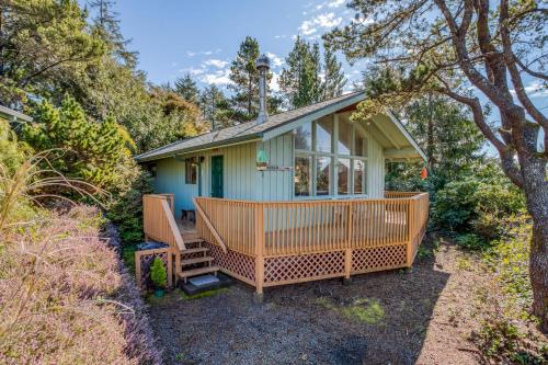 a small blue house with a large front porch at The Beach Cabin MCA 736 - Meredith Lodging in Manzanita