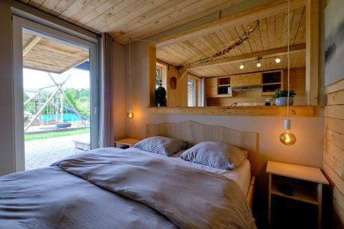 1 dormitorio con cama y ventana grande en La tanière, en Chaudfontaine