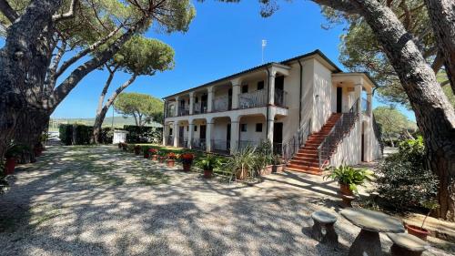 a building with stairs and trees in front of it at Hotel Boschetto in Follonica