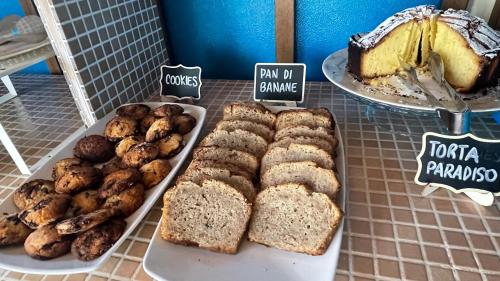 a table with bread and muffins and a cake at Hotel Boschetto in Follonica