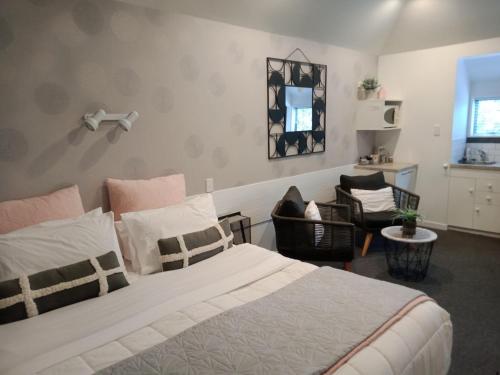 a bedroom with a large bed and a chair at Four Peaks Motel in Geraldine