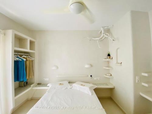 a white bedroom with a bed and a closet at Deluxe Studios & Suites Ageri-Milos in Adamantas
