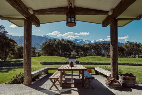 a patio with a table and a view of mountains at Kanuka Terrace - Luxury Strawbale House in Kaikoura