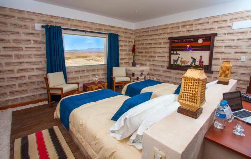 a bedroom with two beds and a window at Hotel de Sal Luna Salada in Colchani
