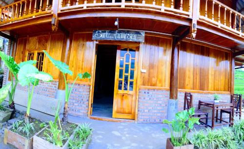 a small building with a door and a table and chairs at Surelee Homestay in Sa Pa
