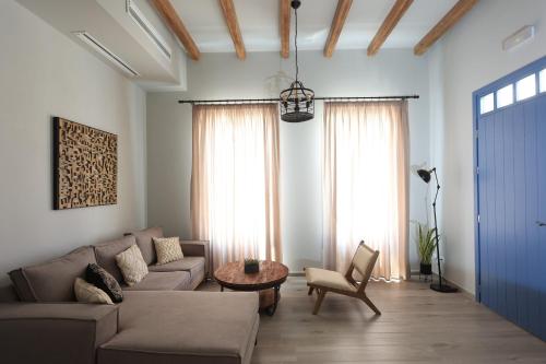 a living room with a couch and a table at Captains Villas & Suites in Apróvaton