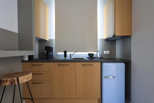 a small kitchen with a sink and a refrigerator at Captains Villas & Suites in Apróvaton