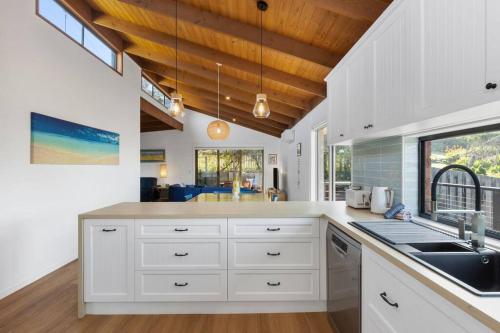 a kitchen with white cabinets and a sink at Sea Breeze on Orton - 5 minute walk to the beach! in Ocean Grove