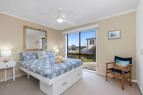 1 dormitorio con cama, espejo y ventana en Sea Breeze on Orton - 5 minute walk to the beach! en Ocean Grove