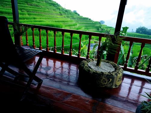 a vase sitting on a balcony with a view of a rice field at Surelee Homestay in Sa Pa