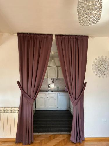 a kitchen with purple curtains in a room at Holiday Home Hodo in Sarajevo