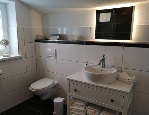 a white bathroom with a toilet and a sink at Flying Dutchman - a28400 in Schönberger Strand