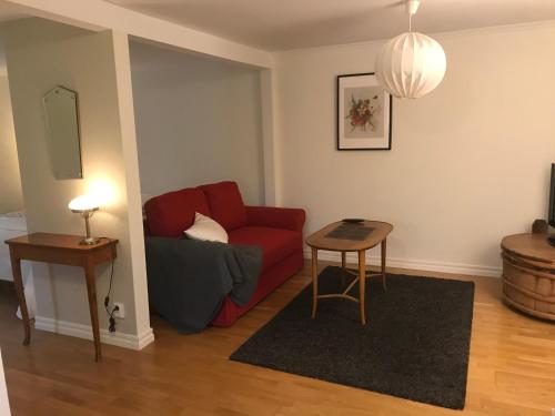 a living room with a red couch and a table at Hatty's Guesthouse in Motala
