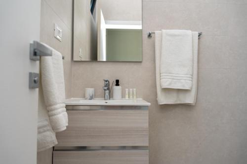a bathroom with a sink and a mirror and towels at Korcula Hill in Korčula
