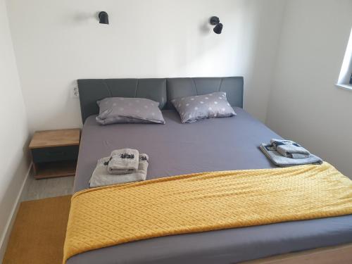 een bed met twee handdoeken in een kamer bij Apartman Retro with heated pool and gym for 8 in Murter