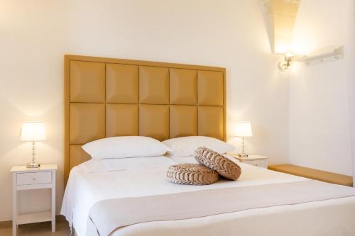 a bedroom with a large white bed with two lamps at TENUTA DOROLIVO in Otranto