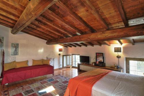 a living room with a bed and a television at Country Home CA' ISIDORA in Lazise