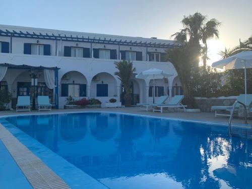 a hotel with a swimming pool in front of a building at Villa Ilios in Fira